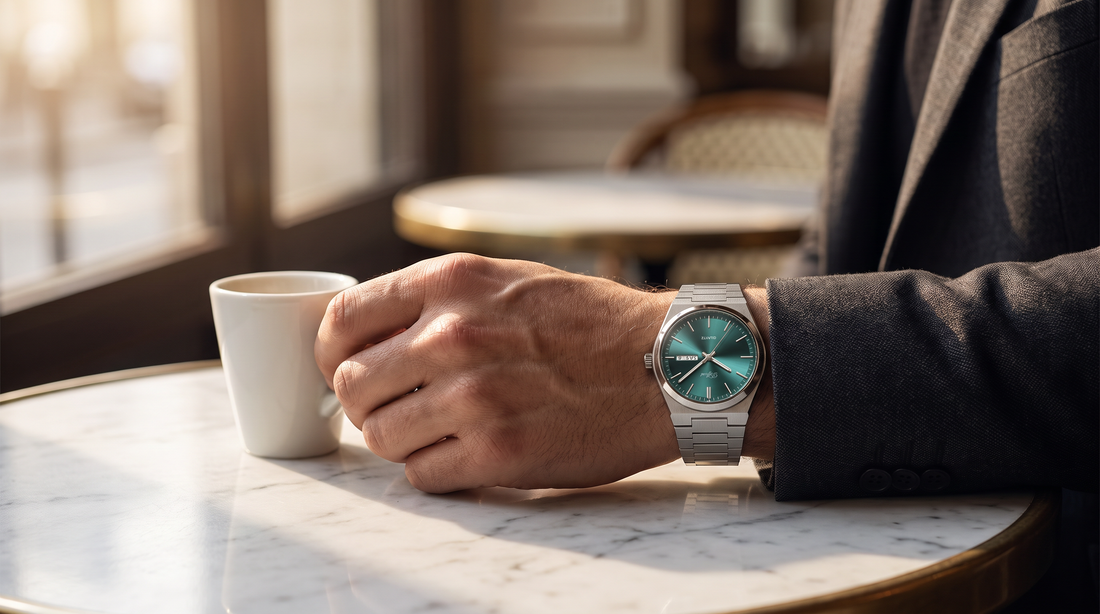 Man in a charcoal jacket wearing the DIFFRNT Fortuno watch holding an espresso at a marble café table