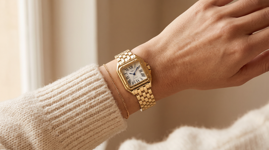 Slender wrist wearing the petite gold DIFFRNT Calista watch on a cream knit sleeve