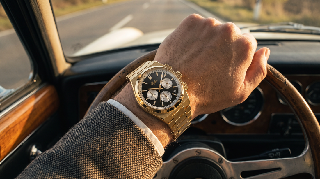 DIFFRNT Prague gold watch with black dial and subdials on a wrist at a classic car steering wheel